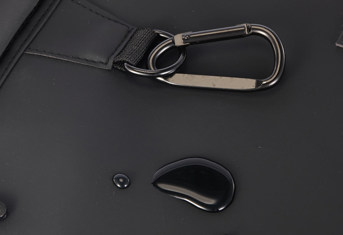 Close-up of the GA Backpack carabiner, D-ring and matte front panel with water droplets